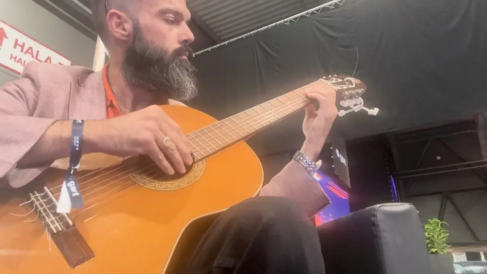 A conference musician playing guitar