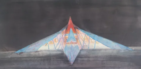A triangular illuminated structure against a dark sky