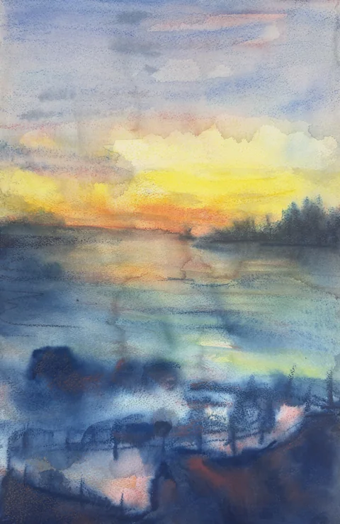 A golden sunset reflected on the sea beside a curved terrace