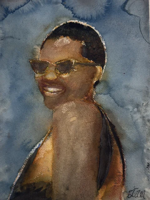 A smiling woman wearing sunglasses against a blue background