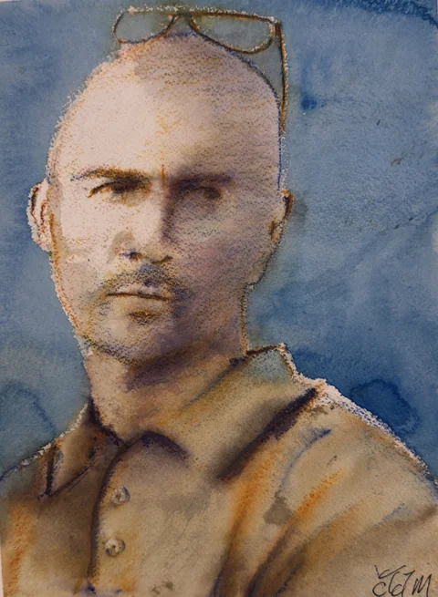 A man in a brown shirt with sunglasses resting on his head
