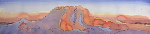An orange mountain ridge beneath a pale sunset sky