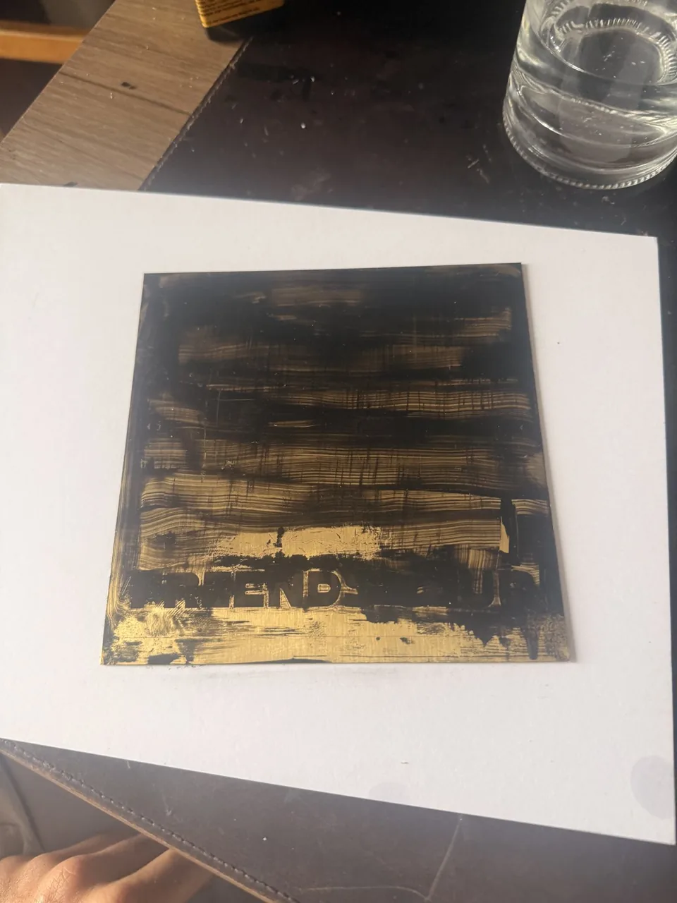 The plate covered in black enamel before wiping