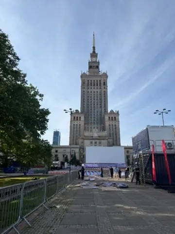 The Palace of Culture and Science in Warsaw, seen from the plaza beneath a blue sky.