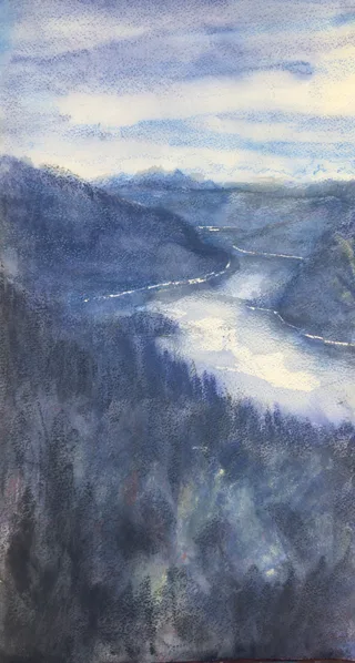 A narrow lake winding through wooded blue mountains