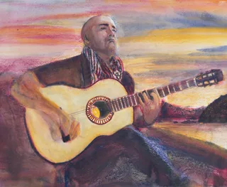 A guitarist playing outdoors in warm sunset light